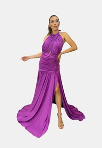 Abito viola con scollo a halter, dettagli arricciati, spacco alto e gonna fluida. Realizzato in un tessuto leggero e morbido.