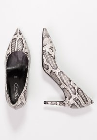 Stiletter med spids tå og slangeskindsmønster, med en glat sort inderside og en blank, struktureret yderside.