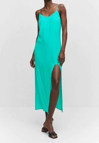 Une robe maxi satinée turquoise avec une fente haute, des bretelles spaghetti ajustables et une texture lisse et fluide.