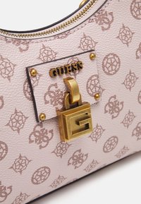 Hellrosa strukturierte Handtasche aus Kunstleder mit einem goldfarbenen Vorhängeschloss-Anhänger, geprägten Logomustern und einem goldfarbenen Reißverschlussverschluss.