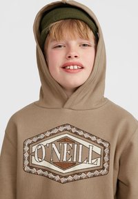 Felpa marrone con un grande logo grafico crema e marrone "O'NEILL" sul davanti. La texture è morbida, con cappuccio e dettagli a coste.