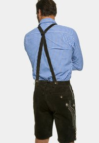 Tradycyjne lederhosen wykonane z ciemnego zamszu, w połączeniu z niebiesko-białą koszulą w kratę. Posiadają czarne szelki i dekoracyjne przeszycia.