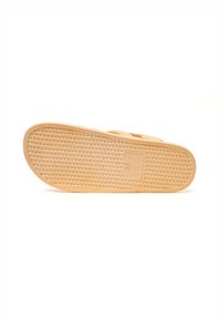 Light tan rubber sandal sole with a textured grip pattern and embossed size label "38" and "Made in Italy." Flat, open-toed design.