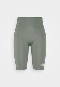 Zielone rowerowe spodenki z wysokim stanem wykonane z elastycznego materiału. Charakteryzują się gładką fakturą i małym białym logo na dolnej części nogawki.