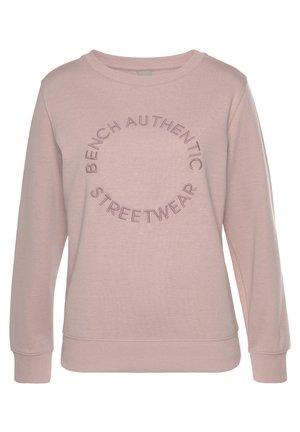 Sweat-shirt rose clair à col rond, manches longues, avec un texte brodé en cercle indiquant "Bench Authentic Streetwear" sur le devant.