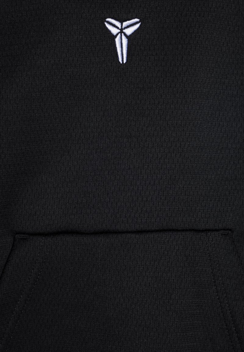 Felpa nera con tessuto testurizzato, dotata di un logo ricamato bianco sul petto e di una tasca frontale. Design semplice senza ulteriori dettagli.