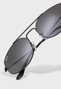 Ochelari de soare aviator negri, cu lentile gri închis, având un pod dublu și tampoane nazale transparente pentru confort.