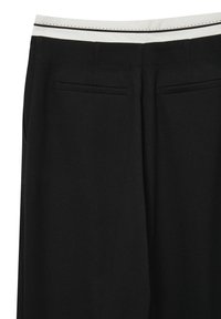 Schwarze Hosen mit glatter Textur, ausgestattet mit einem weißen Bund mit schwarzen Details und zwei Gesäßtaschen.