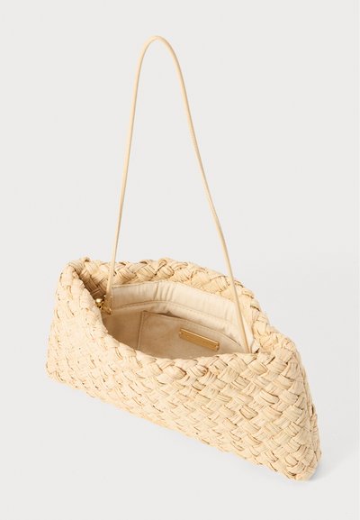Woven straw handbag in light beige with a geometric shape, thin strap, and a gold-tone interior label. Features a soft fabric lining.