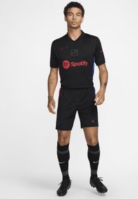 Sort Nike fodboldkit med v-hals-design, blå og røde detaljer på siderne, med Spotify-logo og emblem på brystet.