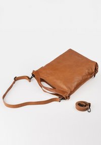 Bruine leren tas met een gladde textuur, rechthoekige vorm en verstelbare schouderband. Inclusief een afneembare band aan de zijkant.