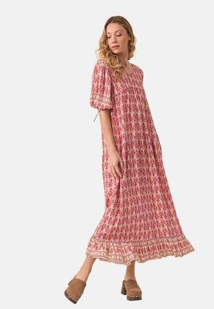 Vestido maxi con mangas cortas abullonadas, patrón floral rosa, diseño en capas y dobladillo con encaje. Combinado con zapatos de plataforma marrones.