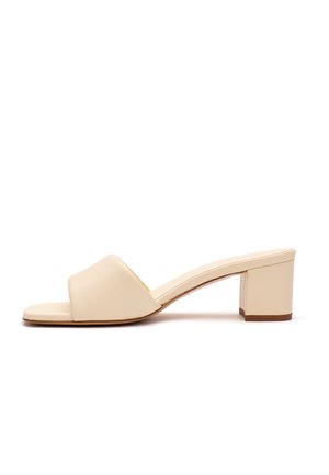Sandalo beige a punta aperta con fascia larga e tacco basso quadrato, visto di lato su sfondo bianco.