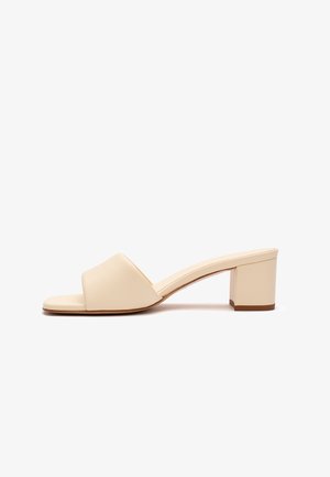 Sandalo beige a punta aperta con fascia larga e tacco basso quadrato, visto di lato su sfondo bianco.