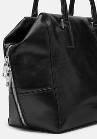 Sac à main en cuir noir avec une forme structurée, des détails en fermeture éclair argentée et une texture lisse. Comprend des doubles poignées et un accent logo subtil.