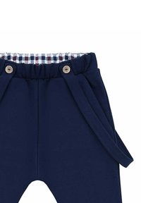 Granatowe spodnie z elastycznym paskiem w talii, z wewnętrzną podszewką w kratę i drewnianymi guzikami. Zawierają boczne sznurki do regulacji.