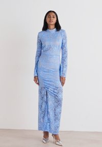 Hosszú ujjú, kék csipke ruha, szoros fazonnal, elöl hasítékkal és magas nyakkivágással. Sima textúra, elegáns dizájn.