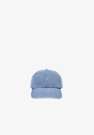 Gorra de béisbol de denim azul claro con un pequeño símbolo de calavera bordado en el panel central delantero, mostrada sobre un fondo blanco.