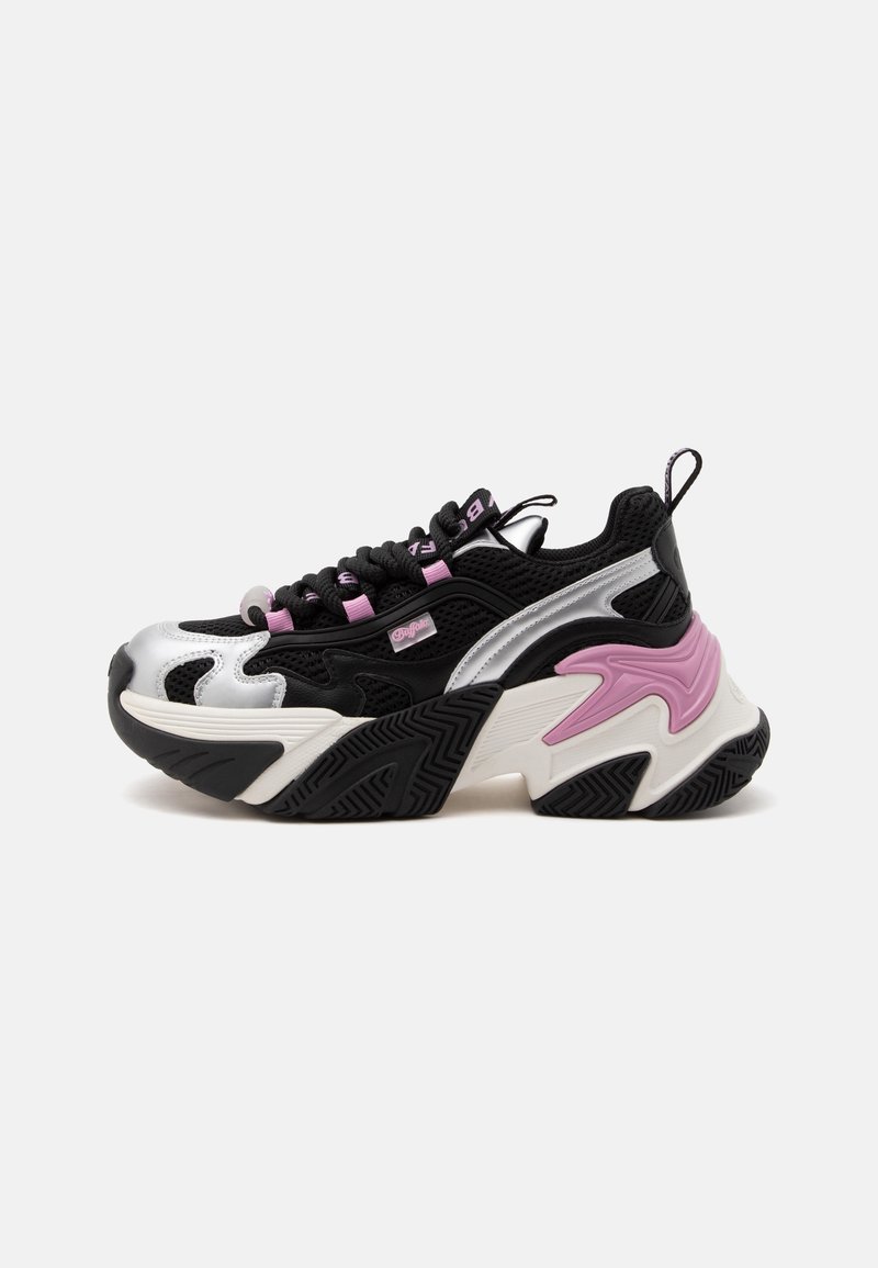 Χοντρό μαύρο και ασημί αθλητικό παπούτσι με ροζ λεπτομέρειες, χοντρή υφασμένη σόλα, δέσιμο με κορδόνια μπροστά και θηλιά στο πίσω μέρος, εμφανιζόμενο σε λευκό φόντο.