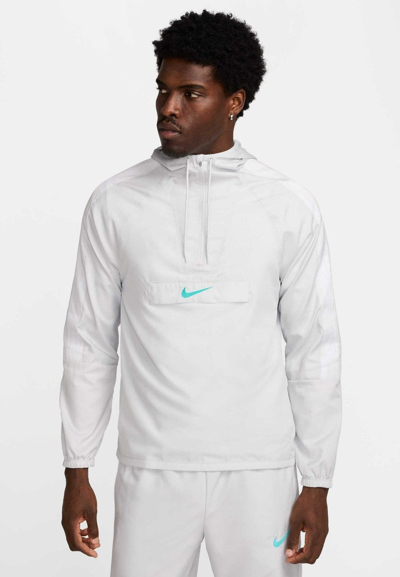 Witte Nike pullover met een halve rits en capuchon, voorzien van een turquoise logo op de borst. Gemaakt van een gladde, lichtgewicht stof met elastische manchetten.