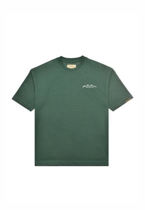 Camiseta de manga corta de color verde oscuro con cuello redondo y pequeño texto blanco que dice "Rue De Monaco San Francisco" en el pecho izquierdo.