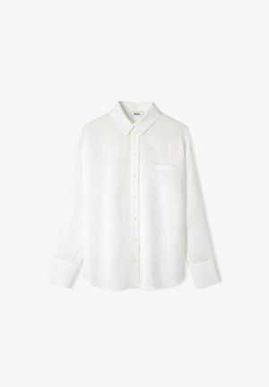 Witte long-sleeve shirt van een gestructureerde stof, met knoopsluiting aan de voorkant, kraag, enkele borstzak en subtiele gekleurde stippen overal heen.