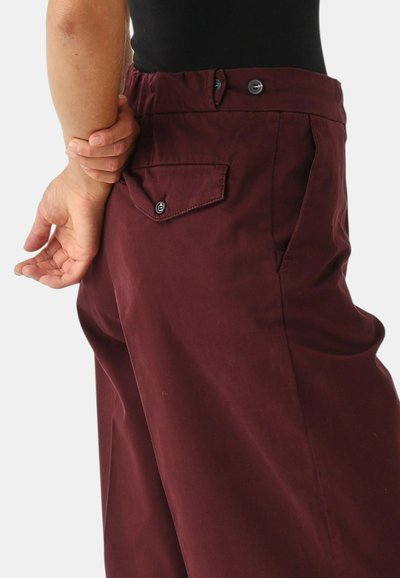 Pantaloni bordeaux a vita alta con tasca posteriore, chiusura con bottone, realizzati in tessuto liscio con vestibilità su misura.