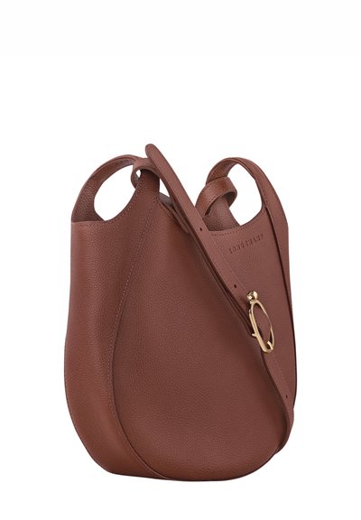 Brown leather shoulder bag with a soft, rounded shape. Features dual handles and a gold-tone hardware accent. Textured surface adds depth.
