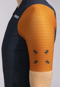 T-shirt de sport à manches courtes avec un corps bleu marine et des manches orange côtelées avec des motifs de flèches noires. Fabriqué en tissu extensible et respirant.