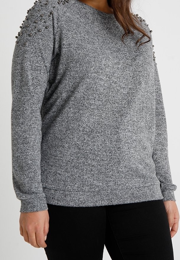 Grijze trui met een gestructureerde stof, voorzien van metalen studs op de schouders, lange mouwen en een ronde halslijn.