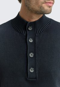 Maglione blu navy in maglia con colletto alto a costine, caratterizzato da un'apertura con bottoni e cinque bottoni rotondi grigi, realizzato in un tessuto texture.