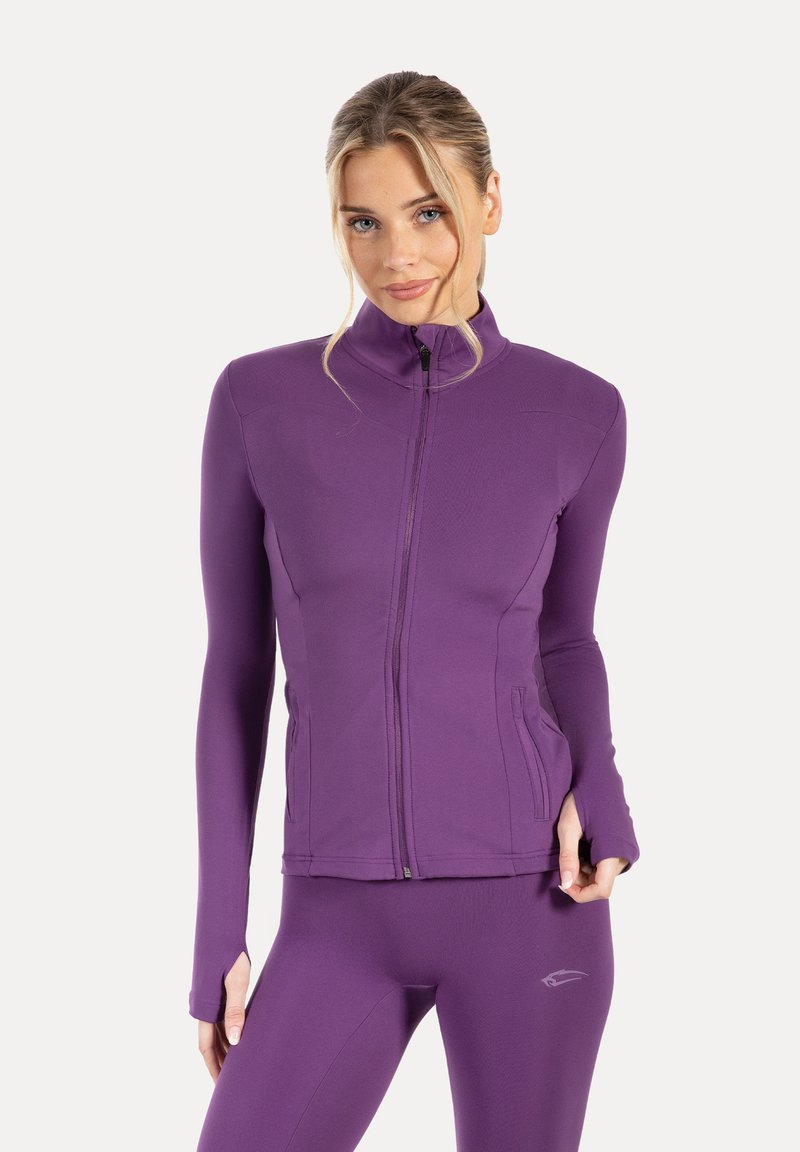 Purple athletic jacket with a high collar, full zipper, and side pockets; smooth texture with fitted sleeves. Paired with matching leggings.