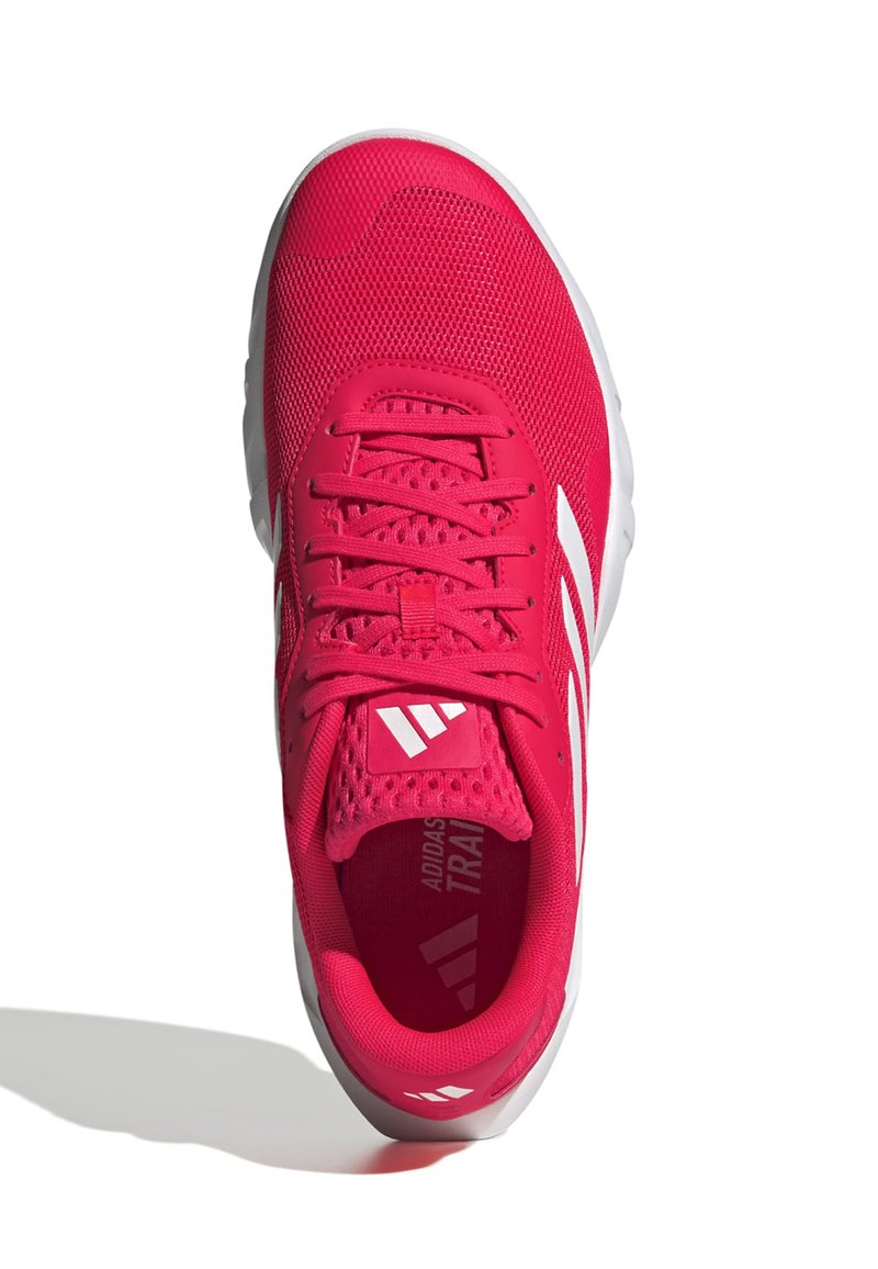 Chaussure de sport rose avec un dessus en mesh, accents blancs et une semelle texturée. Présente un design à lacets et un logo sur la languette.