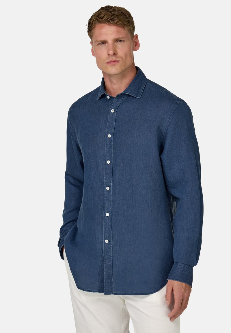 Temno modra denim srajca z dolgimi rokavi, z gumbom spredaj, s koničastim ovratnikom in rahlo teksturirano tkanino. Bele gumbe dopolnjujejo obliko.