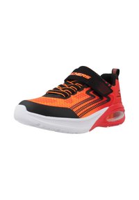 Zapatilla deportiva roja y negra con parte superior de malla, acentos naranjas, cuello acolchado y suela blanca con amortiguación de aire. Cuenta con correa de Velcro.