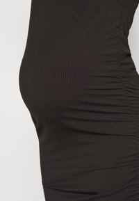 Robe en tissu noir à rayures avec une texture froncée sur le côté, mettant en valeur sa coupe ajustée. Surface lisse avec un léger éclat.