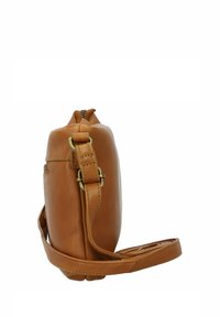 Borsa in pelle color tan con vista laterale che mostra una texture liscia, chiusura a zip e una tracolla regolabile con accessori in tono oro.