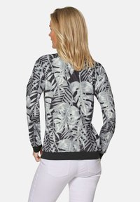 Zwarte sweatshirt met een witte tropische bladerenprint, lange mouwen en een ribgebreide zoom. Zachte textuur geschikt voor casual gebruik.