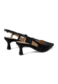 Zapatos de tacón negro tipo slingback con parte superior texturizada, punta afilada y diseño trenzado. Presentan un tacón medio delgado y una correa ajustable en el tobillo.
