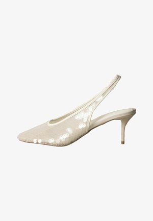 Zapato beige de punta fina con tira trasera, con parte superior de tela adornada con lentejuelas blancas, elevado por un tacón alto y delgado.