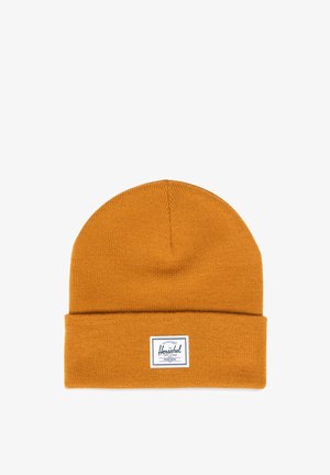 Mosterdgele gebreide beanie met een opgevouwen rand en een rechthoekige merketiket met zwarte tekst voor branding en merknaam details.