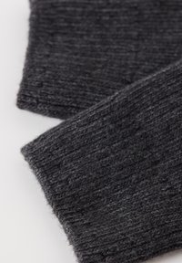 Bufanda de punto gris oscuro con un patrón texturizado, que presenta detalles de canalé y una apariencia suave y ligeramente borrosa. Los bordes están acabados de manera limpia.