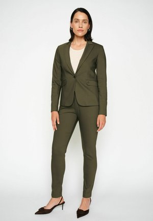 Olive green tailored suit with a fitted blazer and slim trousers. Texture appears smooth; includes a single button and side pockets.