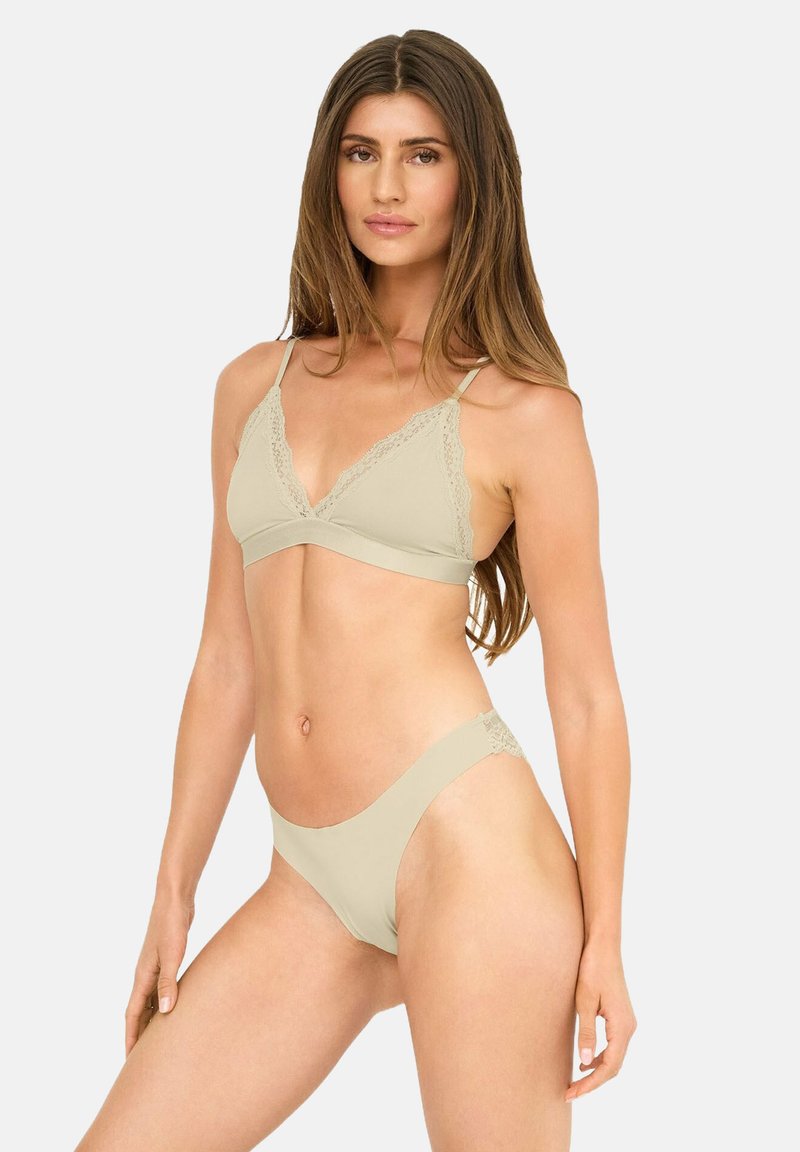 Helle beigefarbene Wäsche-Set mit einem Spitzenrand-Bralette mit verstellbaren Trägern und passenden, niedrig sitzenden Slips mit glatter Textur.