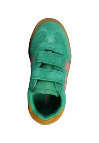 Zapatilla deportiva de ante verde con detalles en rosa, que cuenta con dos tiras de velcro y una suela de goma. La parte superior tiene una forma redondeada y un acabado texturizado.
