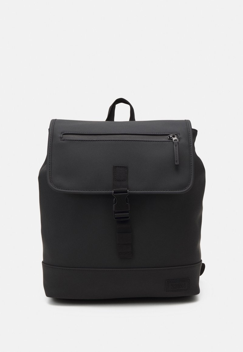 Zaino nero con texture opaca, tasca frontale con zip, pattina pieghevole e chiusura con fibbia regolabile. Etichetta con logo sulla base.