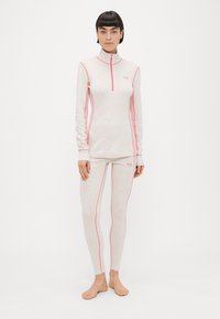 Εφαρμοστό, ελαφρύ αθλητικό σύνολο σε ανοιχτό ροζ με αντίθετες ροζ ραφές και ψηλό γιακά. Το πάνω μέρος διαθέτει μισό φερμουάρ· το κολάν έχει κομψό σχεδιασμό.