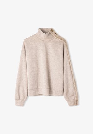 Sweat-shirt beige clair à col cheminée, bordure texturée sur une manche, et détails de boutons. Tissu doux, coupe courte.