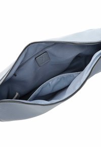 Borsa in pelle azzurro chiaro con chiusura a zip. L'interno è foderato in tessuto liscio e presenta una tasca con zip e due scomparti per l'organizzazione.