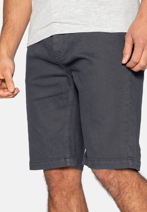 Ciemnoszare spodenki wykonane z miękkiej bawełny o klasycznym kroju, wyposażone w boczne kieszenie oraz widoczne szwy na obrębieniu, zapewniające luźne dopasowanie.